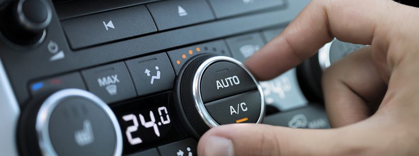 man hand turning on car air conditioning system